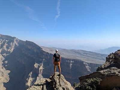 man standing on a rock looking over a mountain range