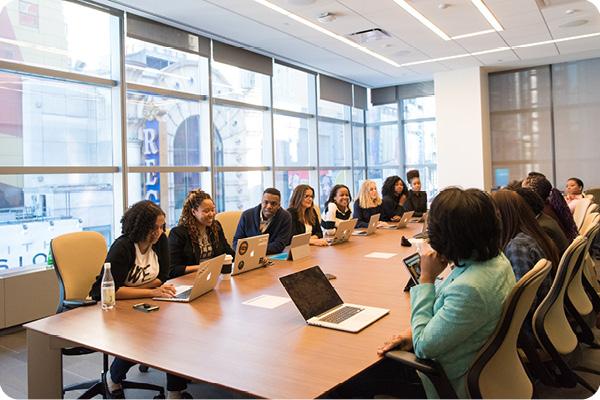 Diverse colleagues sitting at a boardroom table engaged in a discussion